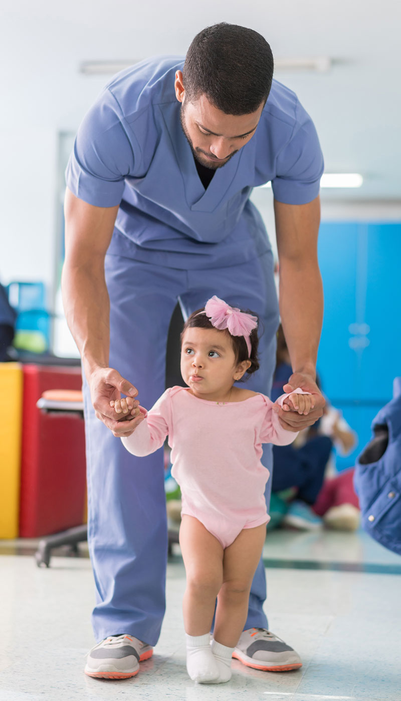 Nurse helping child walk